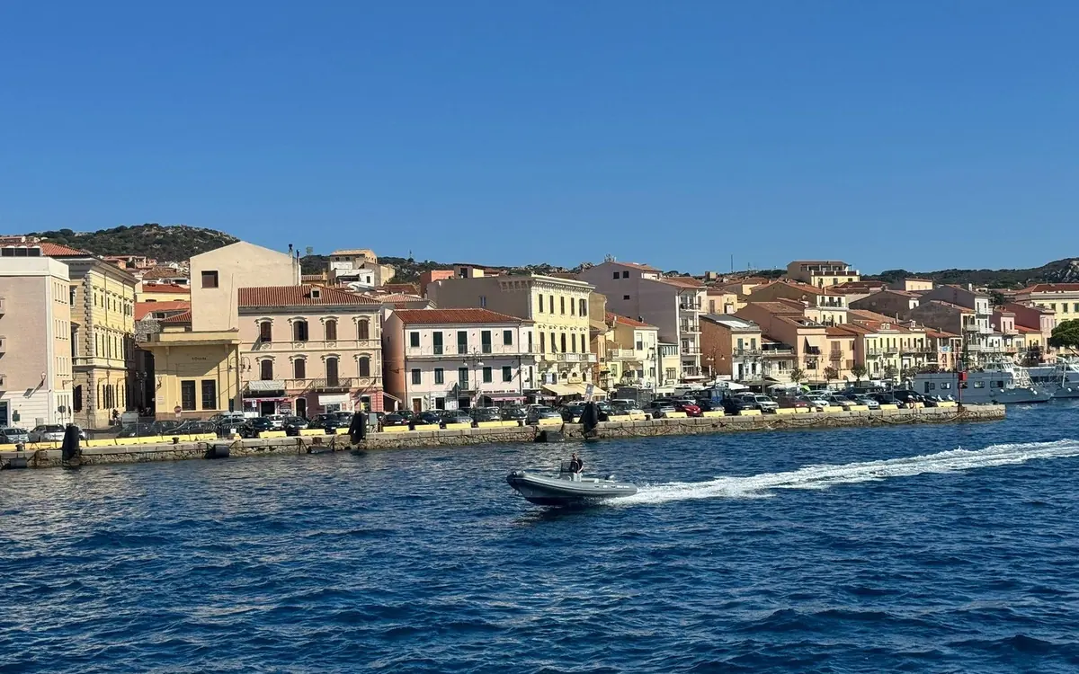 Pastel houses along a town waterfront seen from a boat